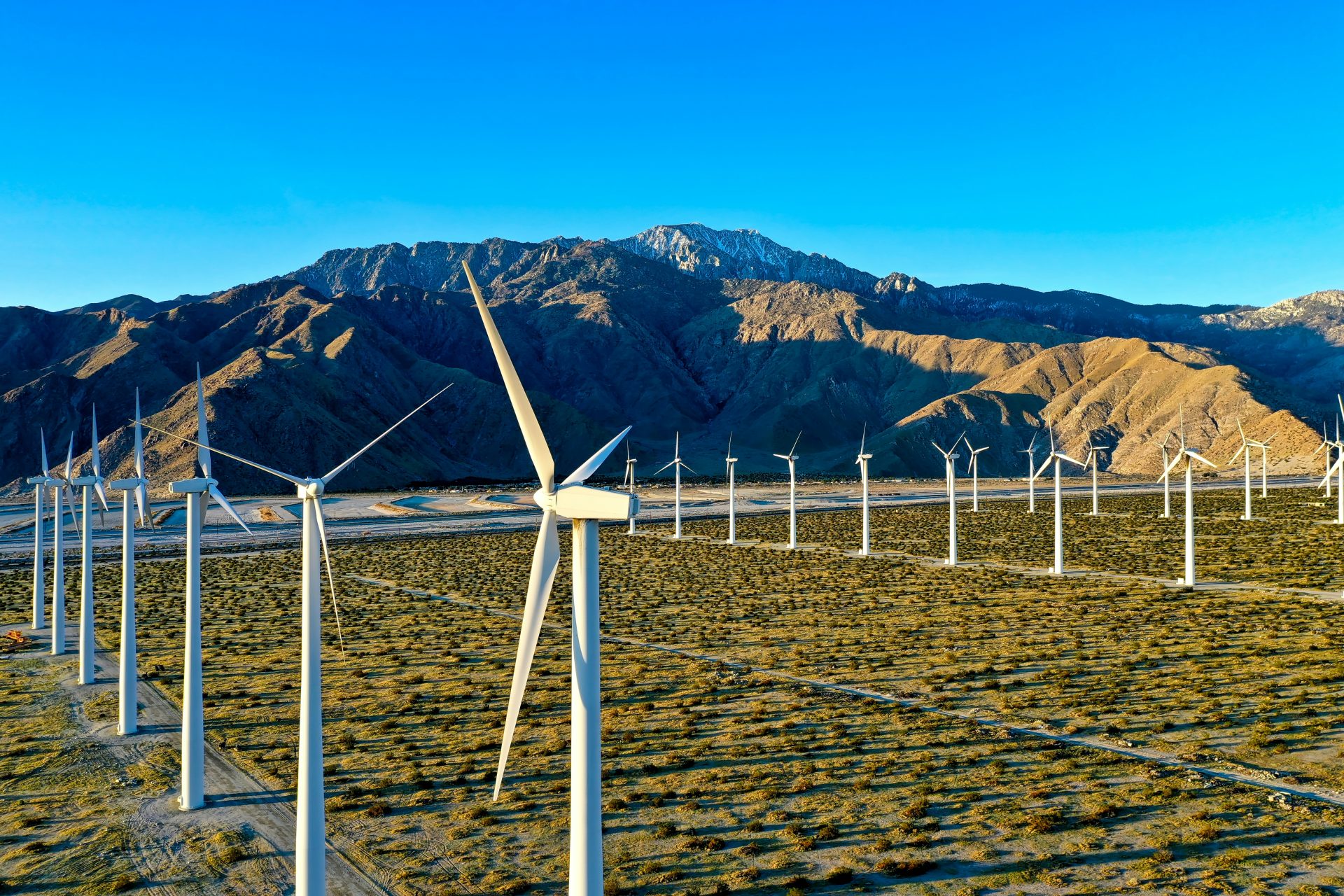 white wind turbines on brown sand during daytime